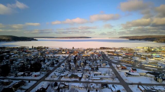 Stunning aerial perspective of munising, michigan, blanketed in snow next to frozen lake superior
