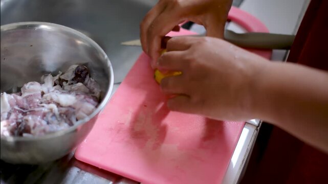 close up of a person's hand squeezing lemon onto seafood to remove the fishy smell from the food