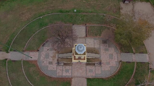 A top-down aerial drone shot of Čegar in Ni&scaron;, gradually revealing the battle monument and the surrounding landscape, emphasizing its historical importance and scenic setting.