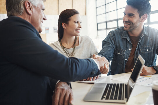 Business, handshake and smile of couple with financial advisor for investment or savings success. Finance, meeting or wealth management with broker and man shaking hands in home for agreement or deal