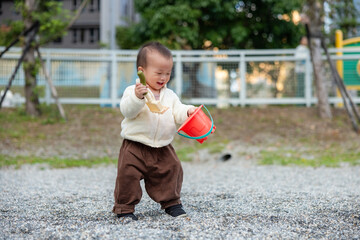 Baby Exploring Pebbles Using Colorful Toy Tool