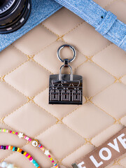 A close-up of a small silver metallic mini bag placed on a leather surface.