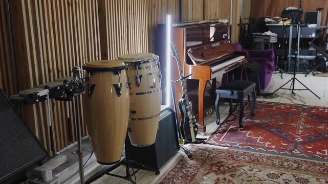 Musical instruments in a recording space with a piano and congas