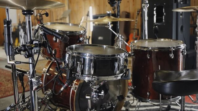 Drum setup in a music studio with various instruments around