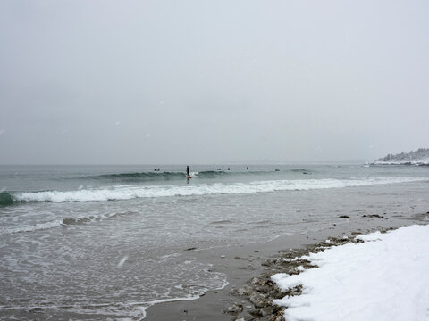 Surfer on a small wave during a winter storm at Higgins Beach