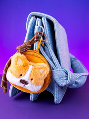 A close-up of a soft, brown plush wallet featuring an adorable and funny puppy design on blue bag