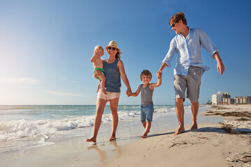 Walk, holding hands and love with family at beach for summer vacation, bonding and support. Connection, tropical holiday and weekend break with parents and children outdoor for travel and trust © BuyoutReese07/peopleimages.com
