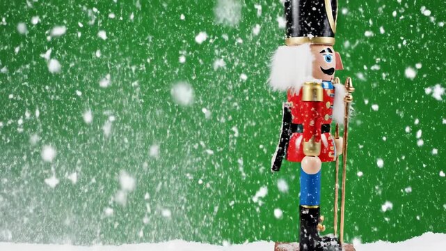 Isolated ornate wooden nutcracker model slowly panning sideways while intense simulated snowfall happens against a bright chroma key green screen background chroma, slowly, ornate