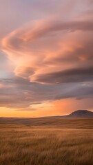 Obraz premium Beautiful landscape with rolling hills and cloudy sky at sunset