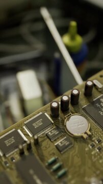 macro vintage circuit board under lamp with flux bottle and glue, restorer workspace showing aged components, tactile solder joints, blurred background, DIY
