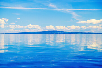 Obraz premium Calm water in Lake Vänern with the hill Kinnekulle in Sweden