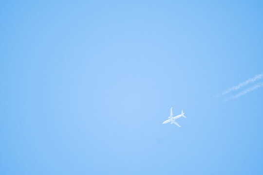 unmarked commercial jetliner leaving contrails behind in its atmospheric flight with a cruising altitude of 35k feet above the sealevel along the Atlantic seaboard