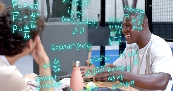 Smiling talking white-tee man at right gesturing at wooden table pink bottle green math, copy space