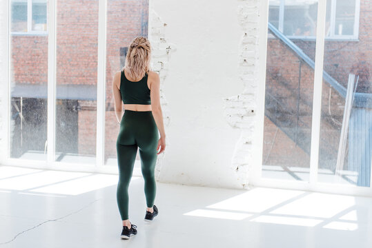 Fitness blonde girl in trending sport outfit training at loft studio