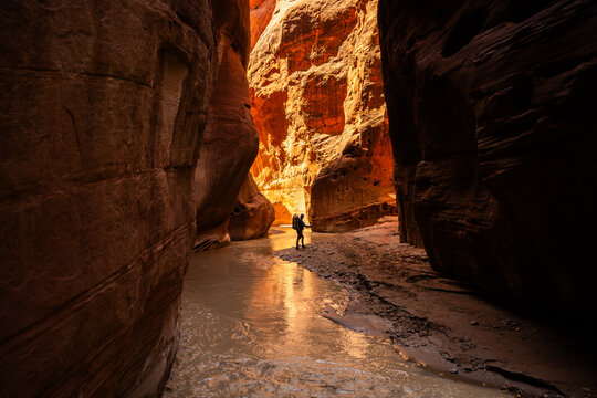 Explorer standing between Dark Canyon Walls in Utah