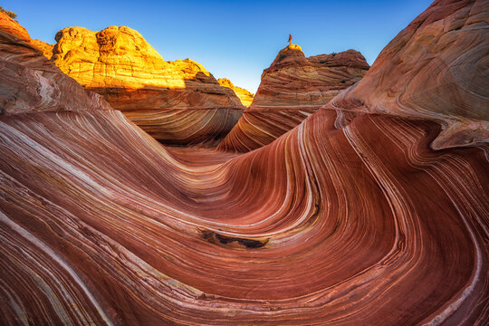 First light hits The Wave and Hiker during Arizona sunrise