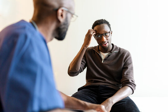 Young man with hearing disability communicating through sign language during doctor's visit