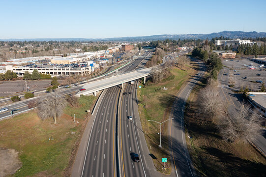 Tigard, Oregon, USA - Jan 24, 2026- Aerial drone picture of OR 217 highway morning traffic, showing vehicles driving north and south with CarMax dealership and Nordstrom shopping area buildings behind