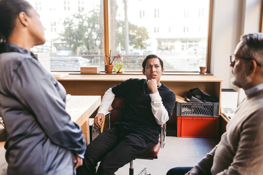 Male business expert discussing strategies with coworkers in architect office