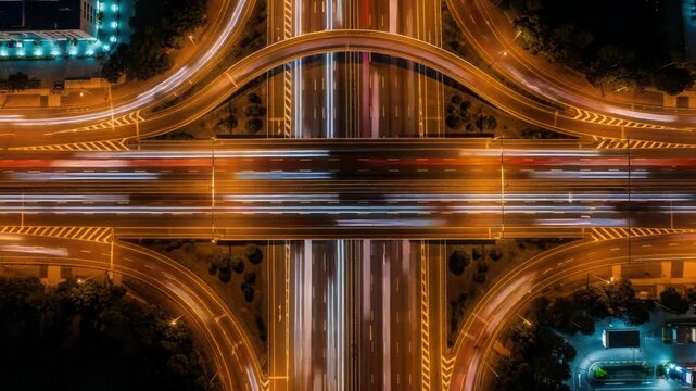 Aerial Night Highway Interchange with Light Trails, Motion Blur, Urban Traffic Flow