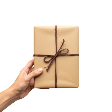 Hand holding wrapped gift box with brown paper and string bow isolated on transparent background
