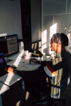 High angle view of male tech professional working on computer while sitting at desk in office