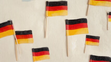 Small German flags scattered on light beige surface