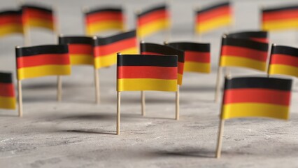 Miniature German flags arranged on textured stone surface