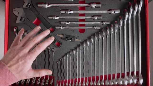 Hand hovering over organized tool drawer