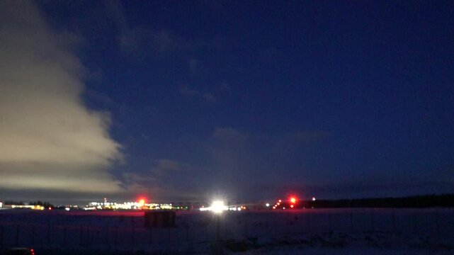 Stockholm, Sweden A plane takes off at night in winter on a runway at Arlanda Airport.
