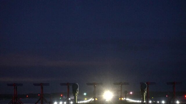 Stockholm, Sweden A plane takes off at night in winter on a runway at Arlanda Airport.