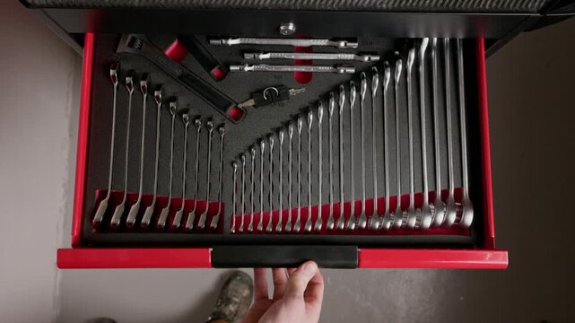 Hand closing organized tool drawer in workshop