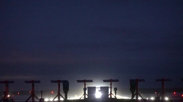 Stockholm, Sweden A plane takes off at night in winter on a runway at Arlanda Airport.