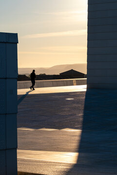 Silhouette at sunset in architecture passage catches light and shadow as urban walk suggests solitude and contrast in evening calm