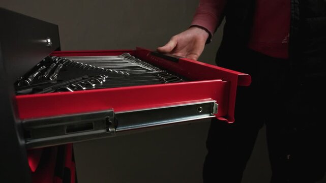 Person opening tool drawer in workshop