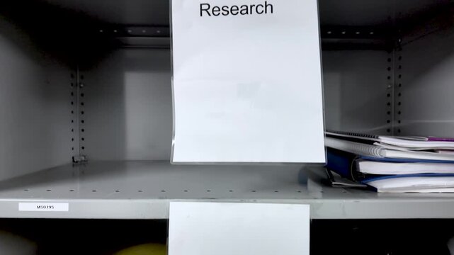 Gray Metal Shelving Unit With Research Label In Office Or Basement For Organization And Storage Featuring Books And Documents For Academic Or Business