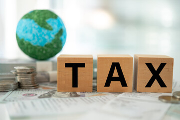 Global Minimum Tax or Global Minimum Corporate Tax concept. A globe and word tax on money banknote.