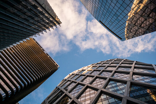 Wide perspective of modern glass skyscraper architecture forming urban city skyline in Paris La Defense under bright blue sky clouds