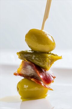 Tapa Gilda aceituna anchoa pimiento en palillo, Pinchito gourmet de alta gama aperitivo espa&ntilde;ol, Fondo blanco para publicidad de bar de tapas espa&ntilde;ol