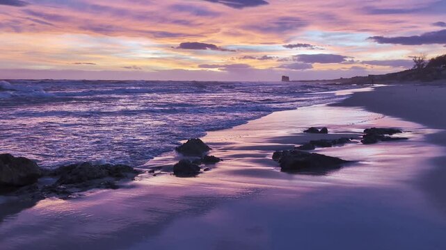 Onde del Mar Jonio sotto un cielo Rosa e Viola al crepuscolo - Marina di Lizzano, Taranto, Puglia, Italia