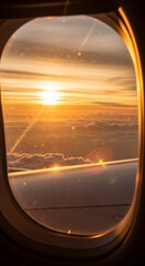 Fototapeta premium View sunset from an airplane window as it flies over the clouds.