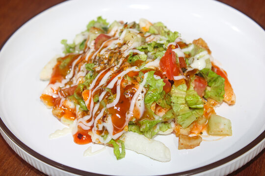 Tasty Loaded French Fries with Fresh Vegetable Salad and Mixed Sauces