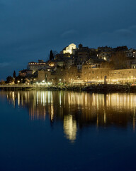 Obraz premium Il borgo di Anguillara Sabazia si riflette sul Lago di Bracciano