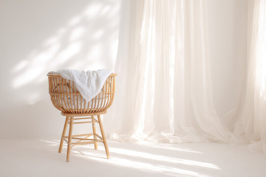 Wicker baby bassinet natural rattan crib white blanket minimalist nursery soft sunlight cozy atmosphere neutral color handcrafted furniture serene peaceful