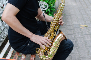 Naklejka premium Authentic Musician Playing Golden Saxophone Instrument Outdoors on a Rustic Bench