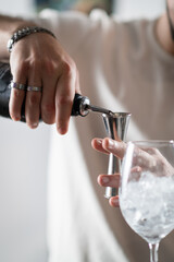 Professional barman preparing cocktails at modern bar counter. Highlights motion, freshness, and creative mixology technique.
