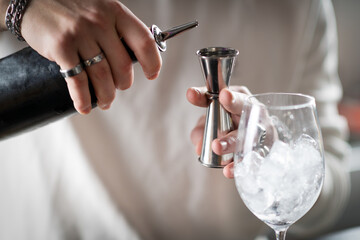Professional barman preparing cocktails at modern bar counter. Highlights motion, freshness, and creative mixology technique.