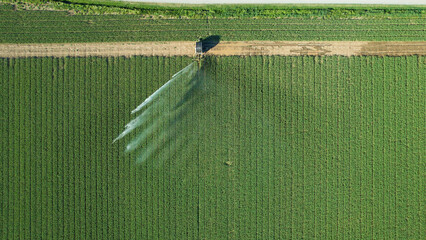 Modern sprinkler irrigation system waters crops in Po Valley, enhancing agricultural resilience © august.columbo