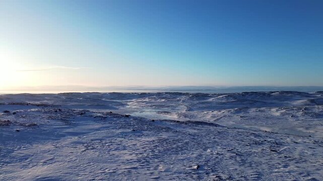 Slow drone push over expansive Arctic tundra landscape outside Iqaluit in Nunavut, Canada.