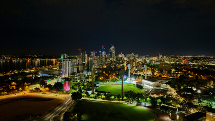 Obraz premium Perth City by Night, Western Australia – Aerial Drone View of Stadium, Illuminated Landmarks and Urban Night Skylines